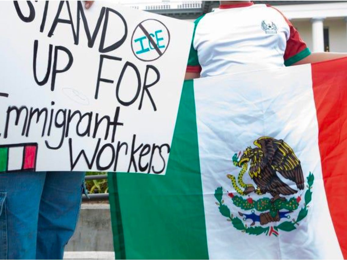 Protest sign supporting immigrant workers and Mexican flag.